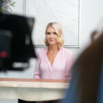 blond white woman in pink in process of corporate video production.