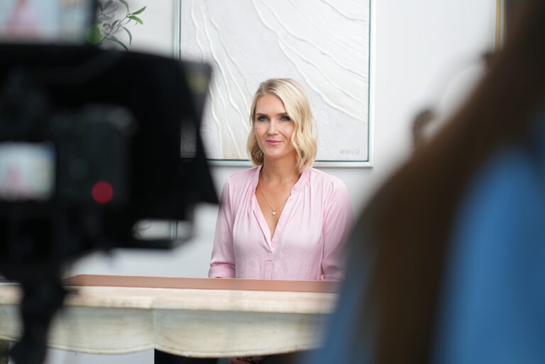 blond white woman in pink in process of corporate video production.