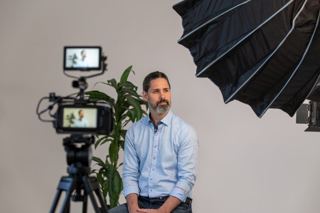 man with beard with a camera and camera equipment in front of him for corporate video production 